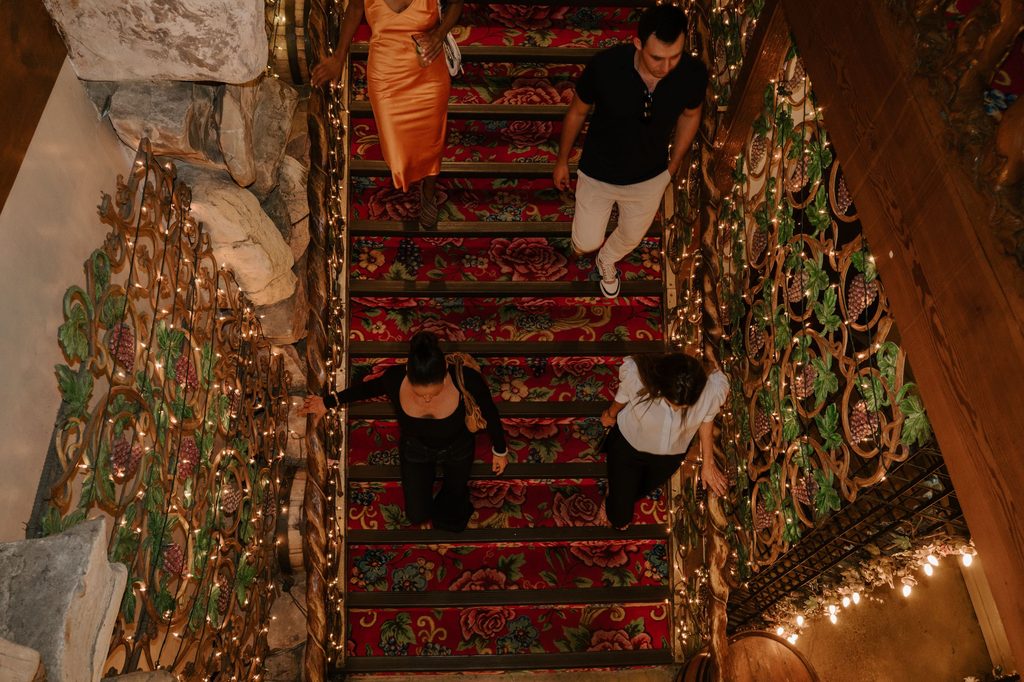 Guests walking down the ornate staircase at Nightcap in San Luis Obispo