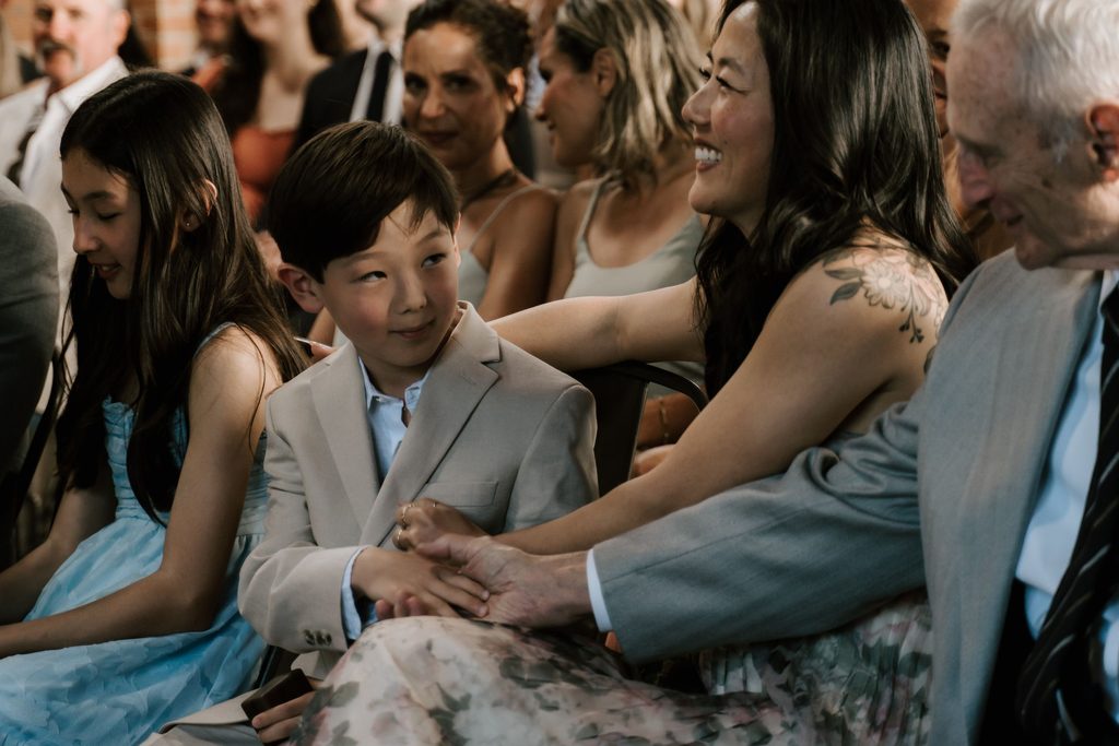 Young guest watching Lily and Ryan's wedding ceremony