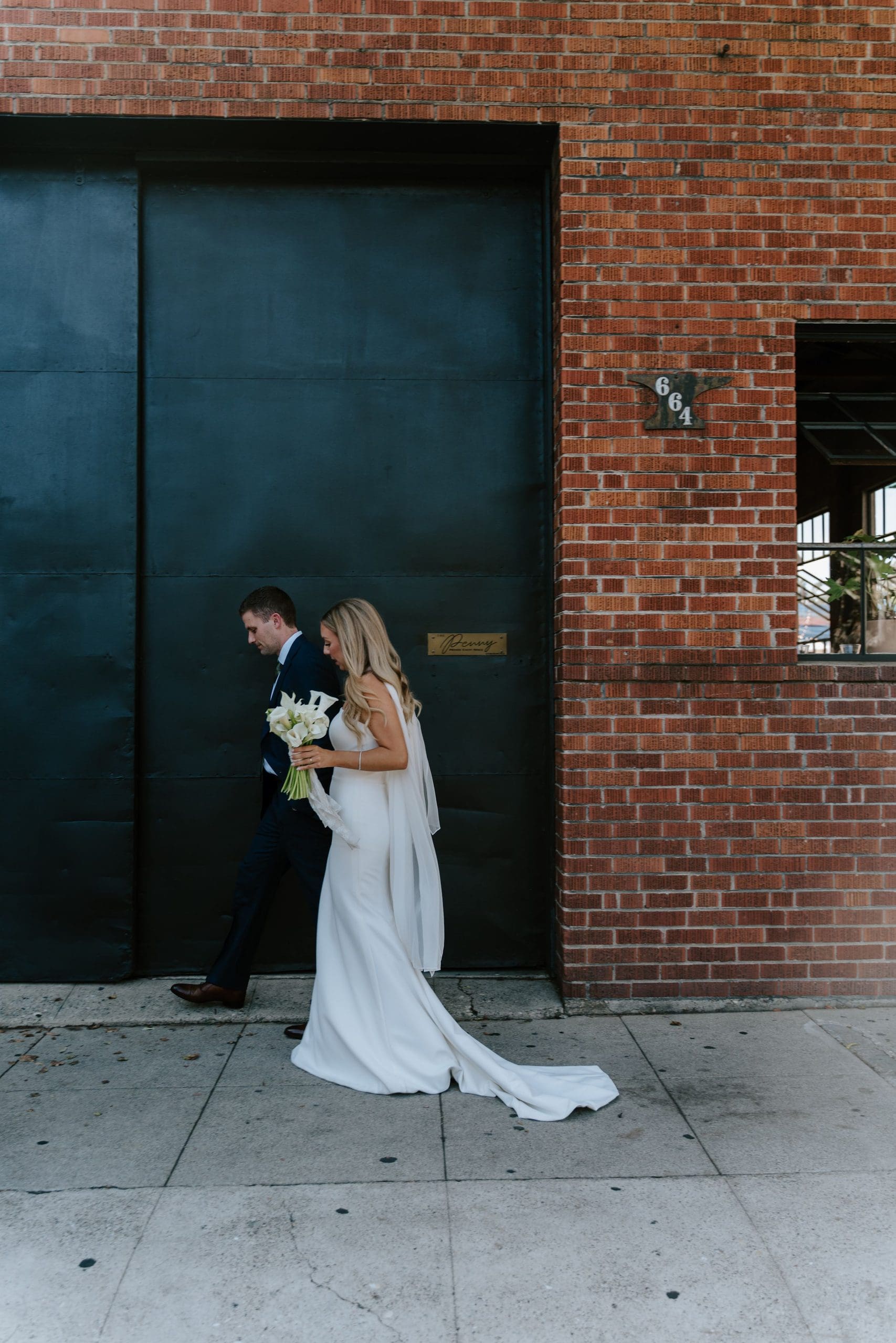 Lily and Ryan posing against a brick wall in downtown San Luis Obispo