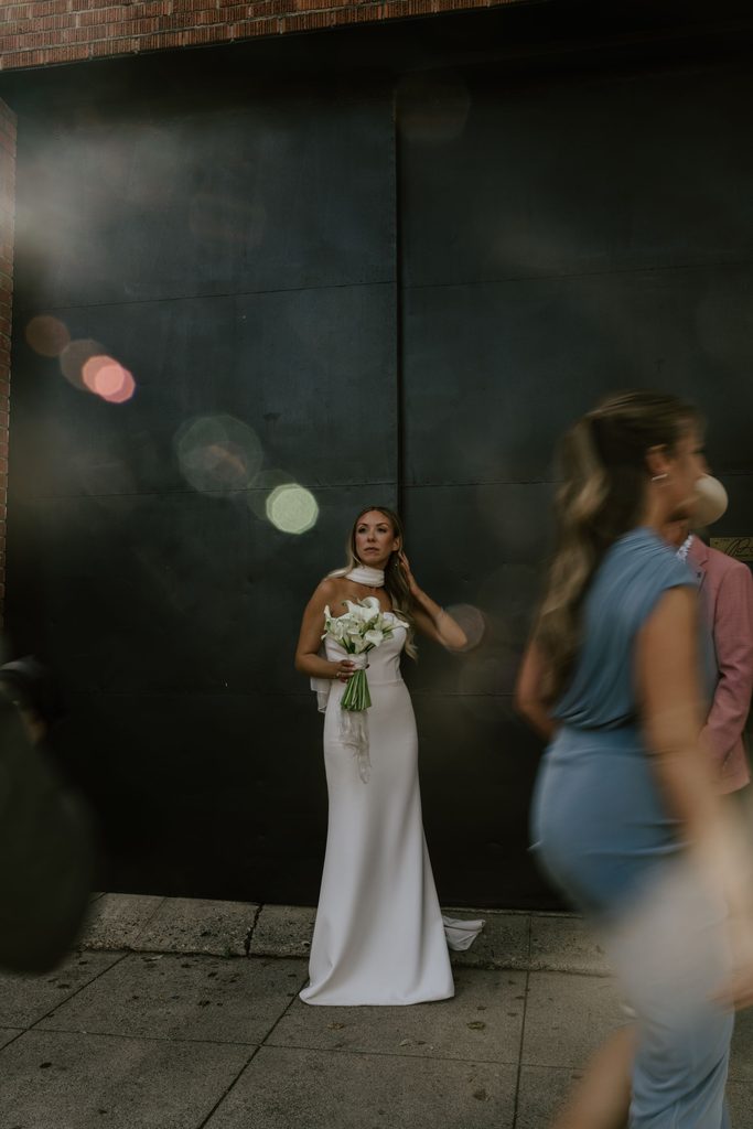 Wedding guests passing Lily during downtown portraits