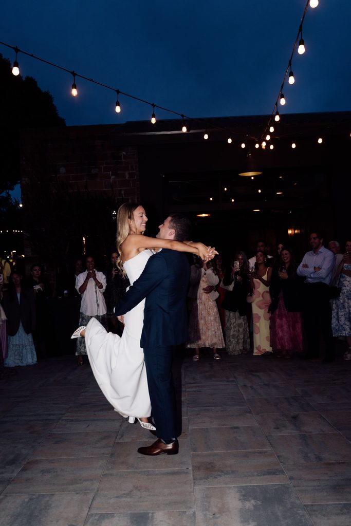 Lily and Ryan dancing under string lights at The Penny