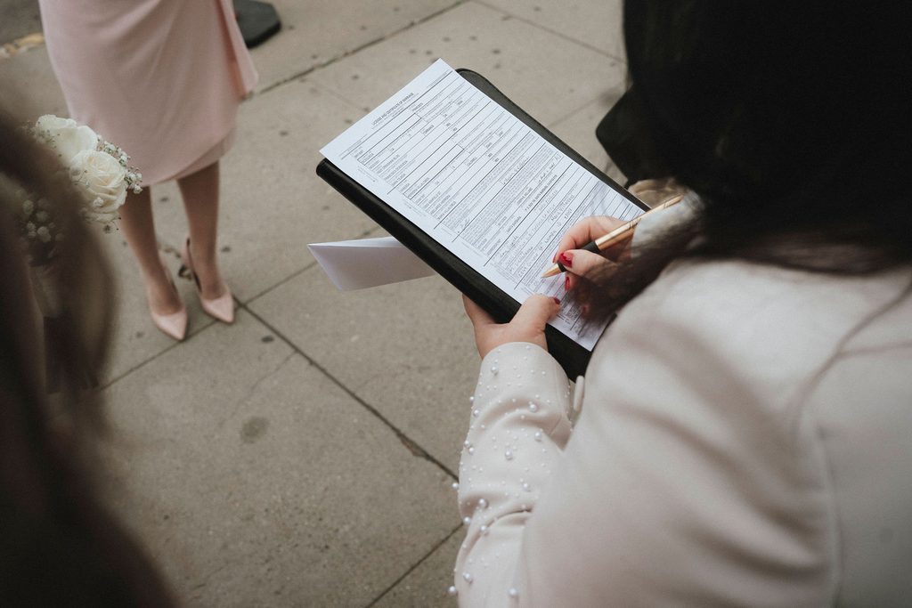 Officiant signing Vanessa and Bryant's marriage license