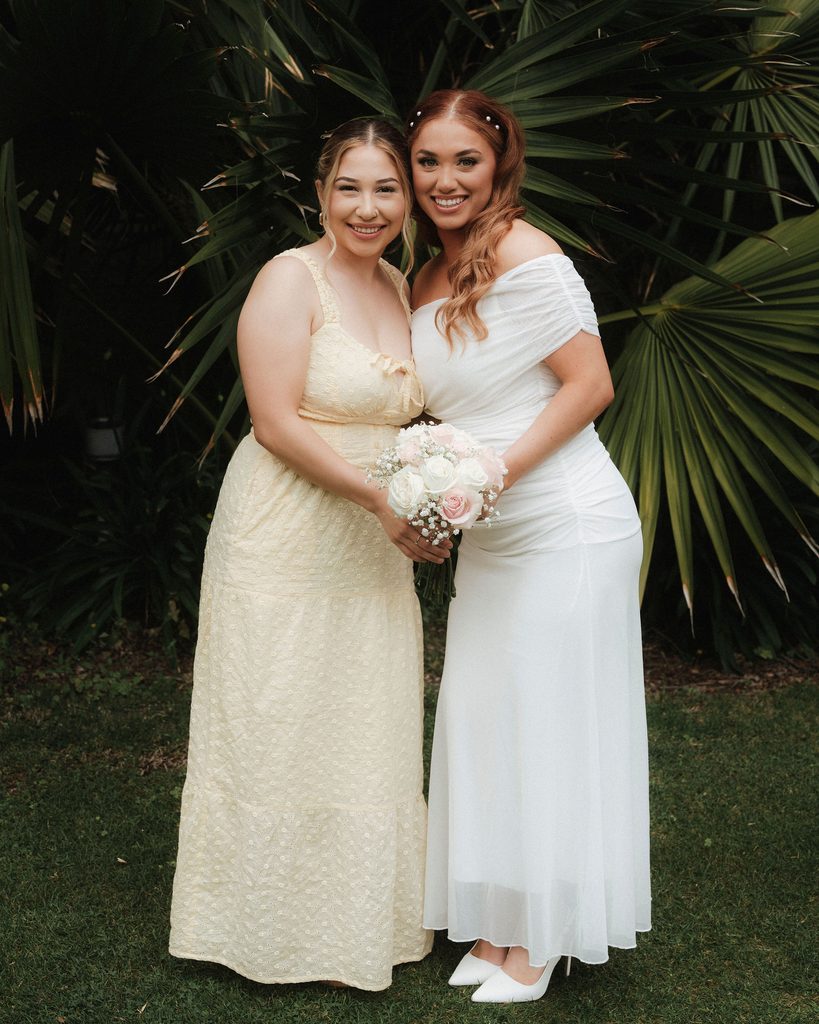 Vanessa posing with a wedding guest in the courthouse garden