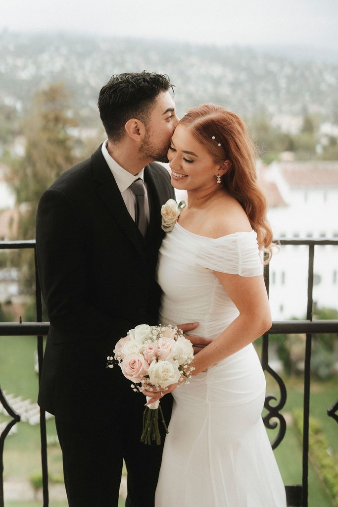 Vanessa and Bryant kissing on a Santa Barbara Courthouse balcony