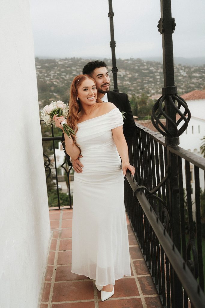 Vanessa and Bryant posing beside a courthouse balcony railing