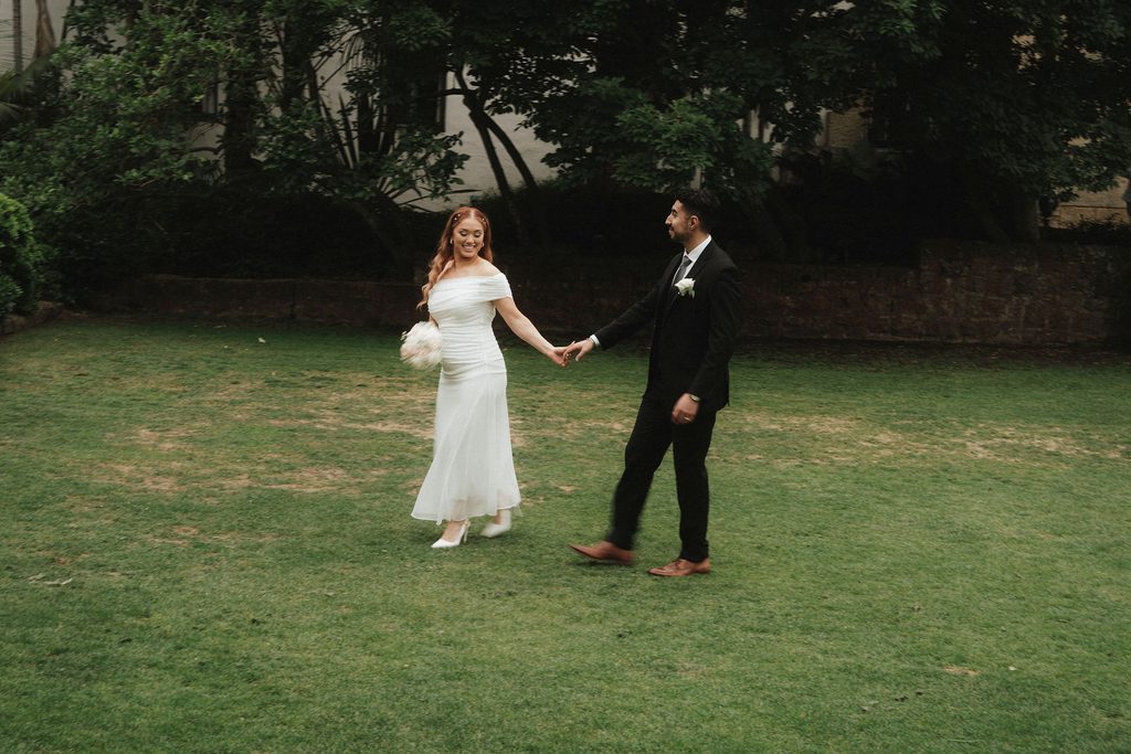 Vanessa and Bryant walking hand in hand across the courthouse lawn