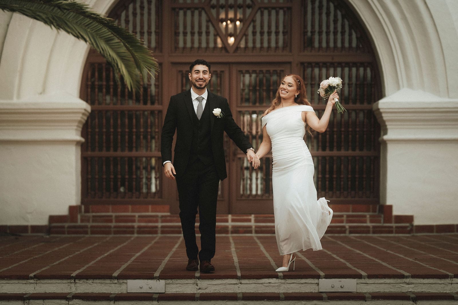 Vanessa and Bryant celebrating in front of the Santa Barbara Courthouse entrance