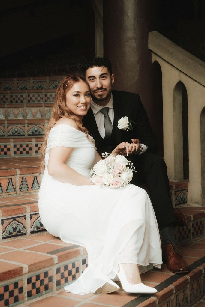 Vanessa and Bryant seated on colorful tiled courthouse stairs