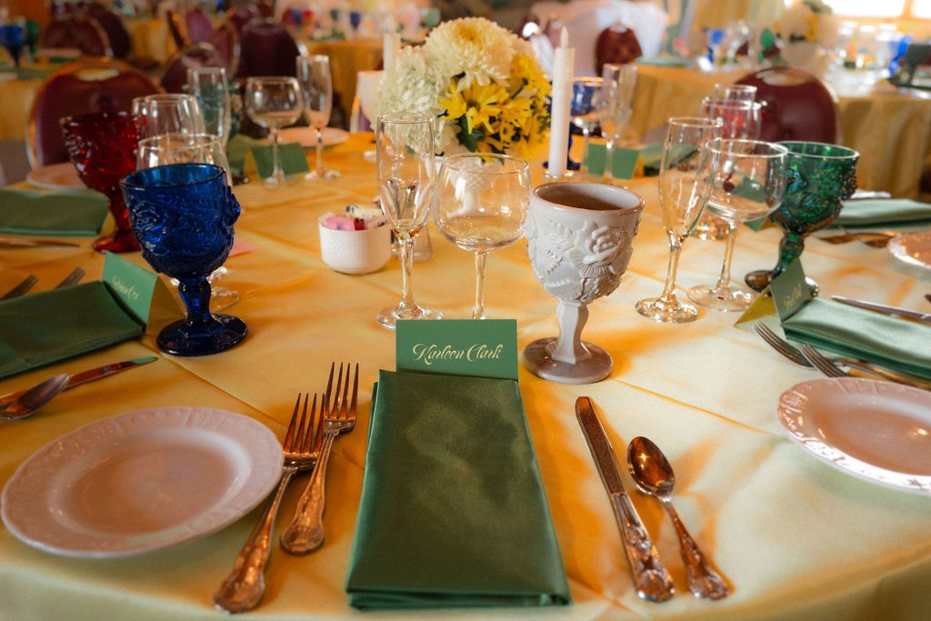 Colorful reception table set with yellow linens and green glassware at the Madonna Inn