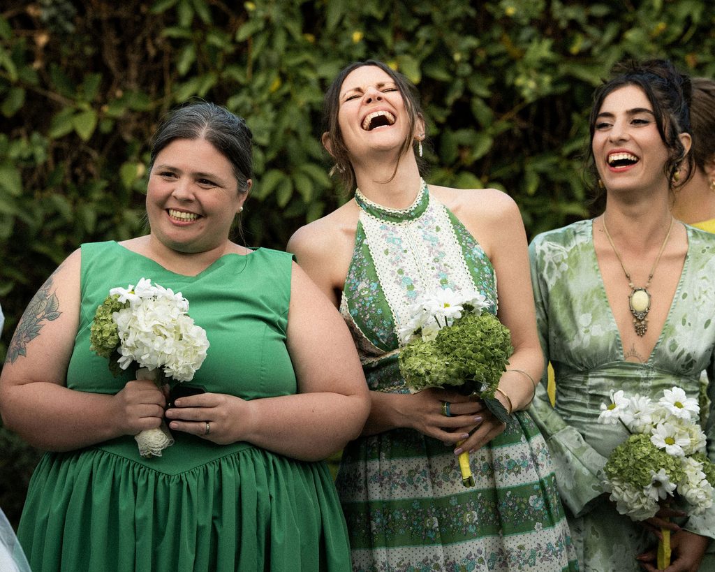 Wedding party laughing with bouquets before the ceremony