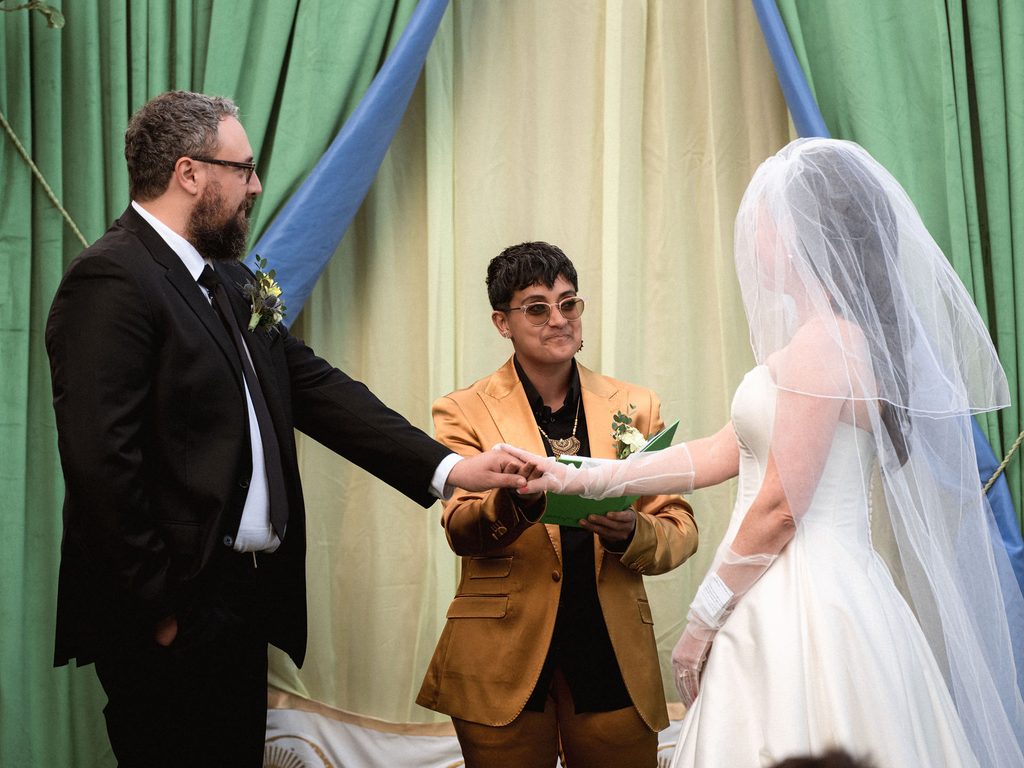 Catie and Tracy holding hands during their Madonna Inn wedding ceremony